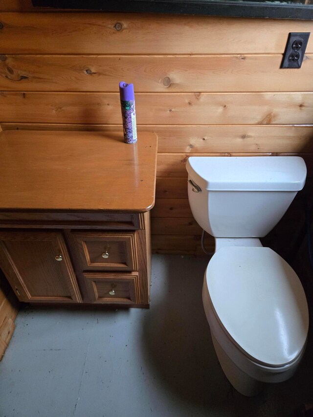 bathroom featuring wood walls and toilet