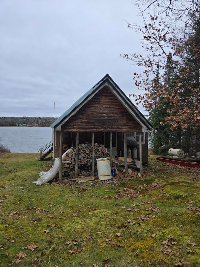 back of property featuring a lawn and a water view