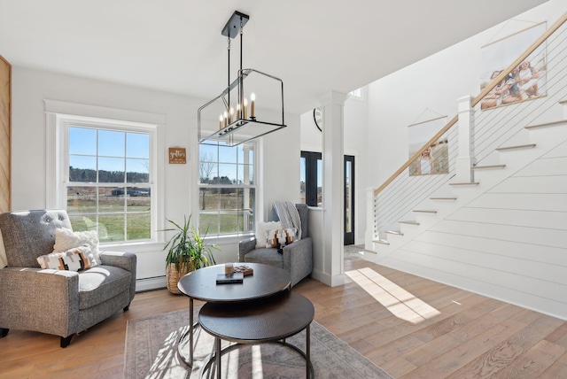 living area with hardwood / wood-style floors, a chandelier, and a baseboard heating unit