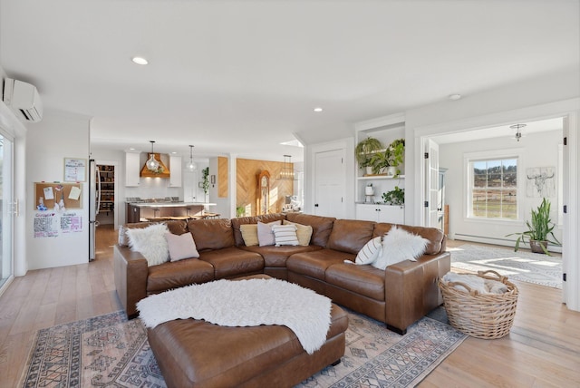 living room with an AC wall unit, light hardwood / wood-style flooring, and a baseboard heating unit