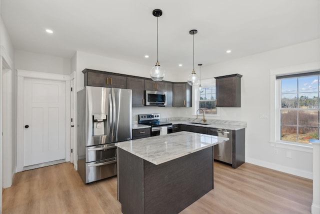 kitchen featuring sink, a center island, light hardwood / wood-style floors, and appliances with stainless steel finishes