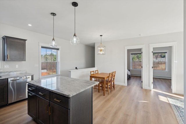 kitchen with dishwasher, a center island, light wood-type flooring, and a wealth of natural light