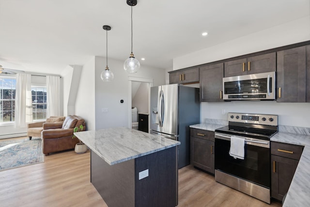 kitchen with a center island, stainless steel appliances, hanging light fixtures, and light hardwood / wood-style floors