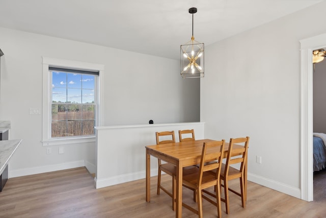 dining area featuring light hardwood / wood-style floors and a notable chandelier