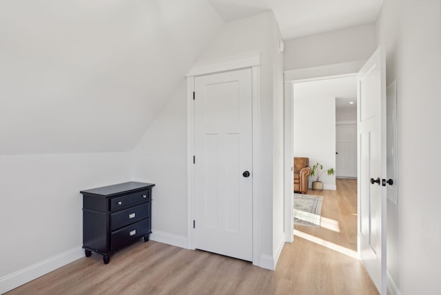 bonus room featuring light wood-type flooring and vaulted ceiling