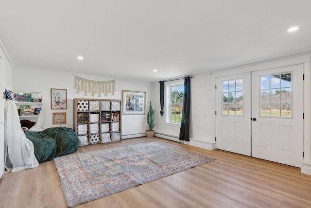 foyer with light wood-type flooring and a baseboard radiator