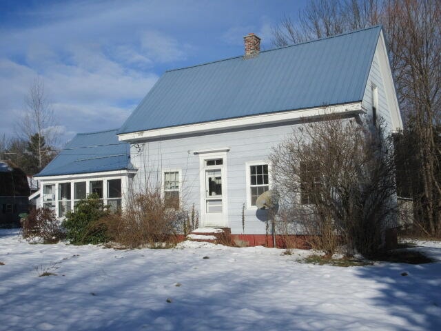 view of snow covered back of property