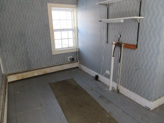 clothes washing area with baseboard heating