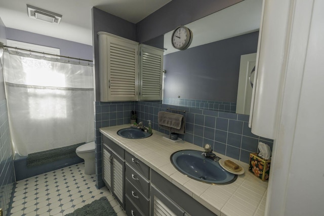 bathroom featuring a shower with curtain, vanity, toilet, and tile walls