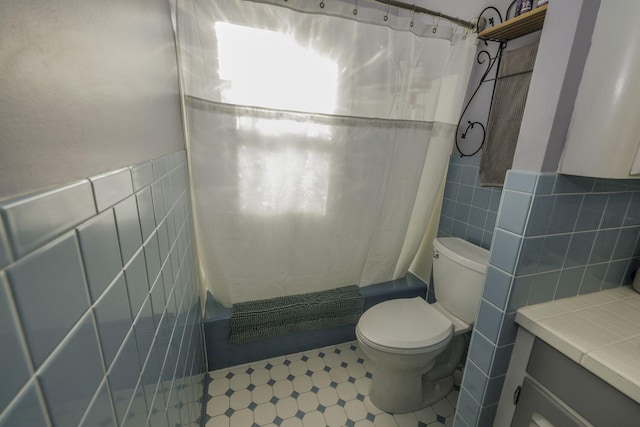 bathroom with shower / bath combo, toilet, and tile walls