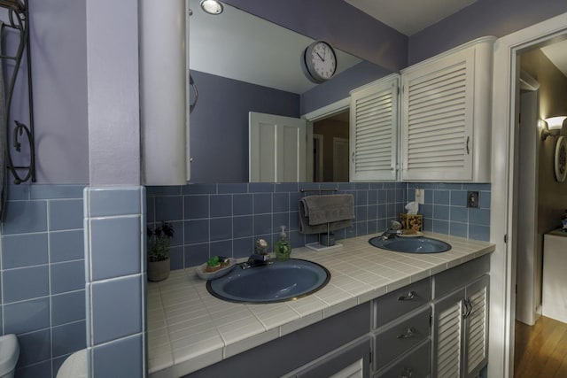 bathroom with decorative backsplash, vanity, and hardwood / wood-style flooring