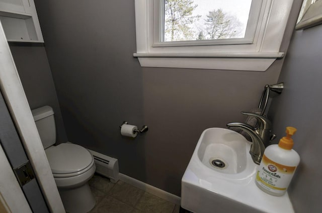 bathroom featuring tile patterned flooring, toilet, and a baseboard radiator