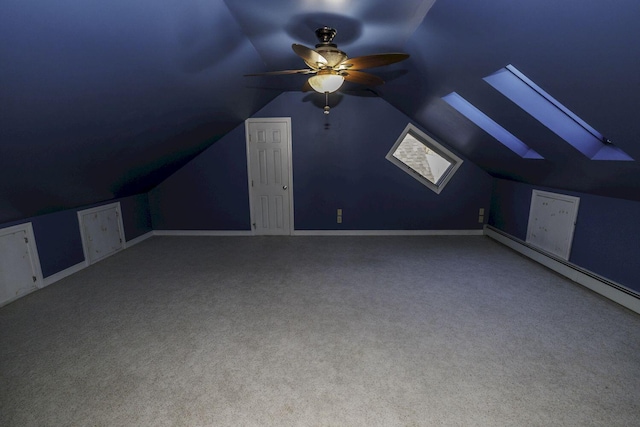 bonus room with carpet floors, ceiling fan, a baseboard heating unit, and vaulted ceiling with skylight