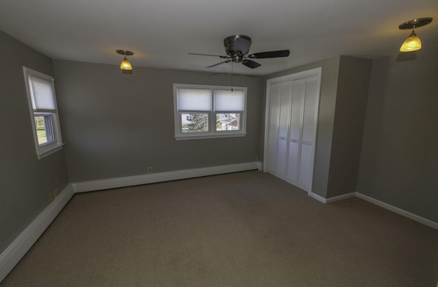 unfurnished bedroom featuring carpet flooring, ceiling fan, a baseboard heating unit, and a closet