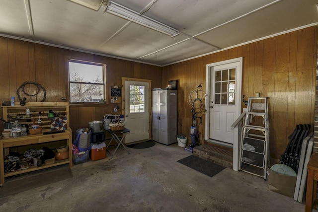 miscellaneous room featuring wood walls and concrete floors