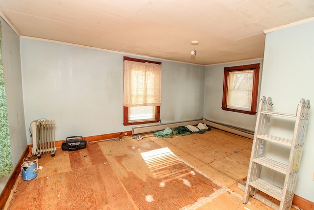 empty room featuring radiator heating unit, a healthy amount of sunlight, and hardwood / wood-style flooring