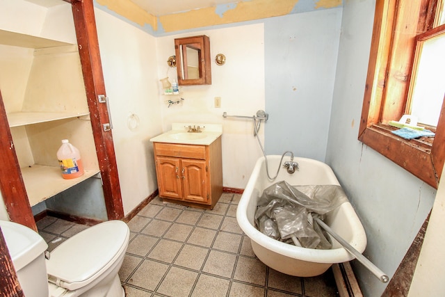 bathroom featuring vanity, toilet, and a tub