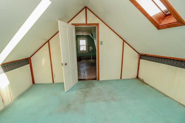 bonus room with lofted ceiling with skylight