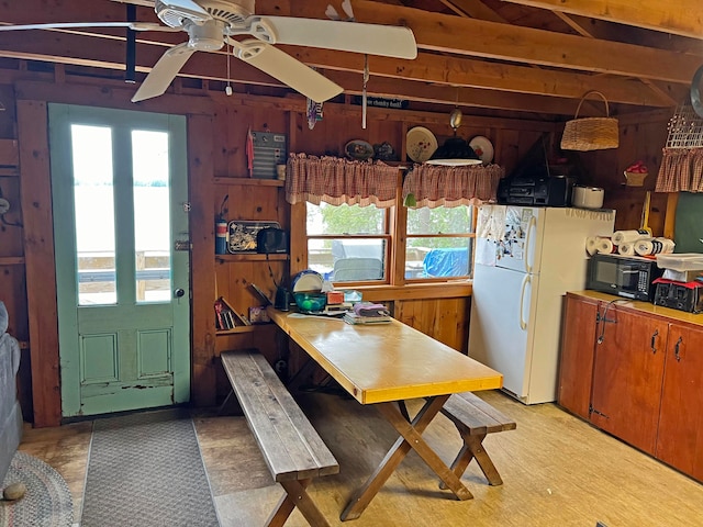 kitchen with wood walls, ceiling fan, and white refrigerator