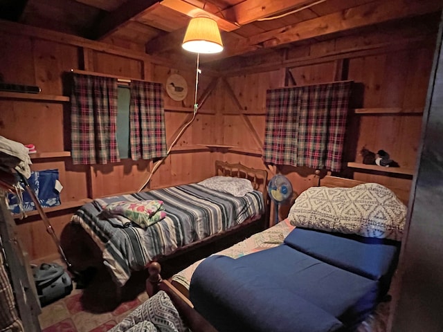 bedroom with beam ceiling, wooden walls, and wood ceiling