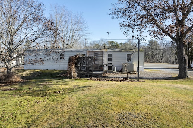 rear view of house featuring a wooden deck and a lawn