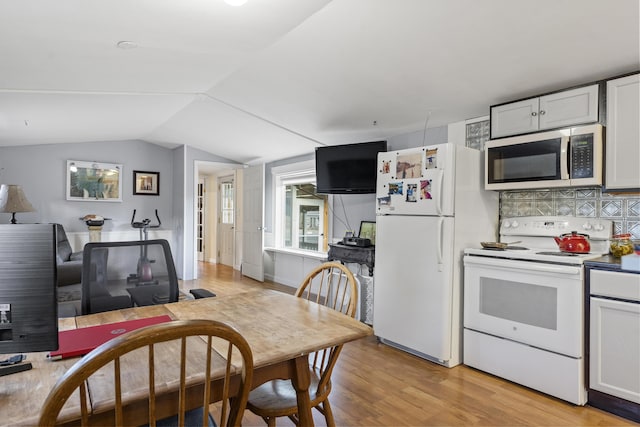 kitchen featuring tasteful backsplash, white appliances, light hardwood / wood-style floors, white cabinetry, and lofted ceiling