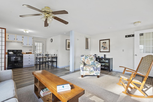 living room with ceiling fan and dark wood-type flooring