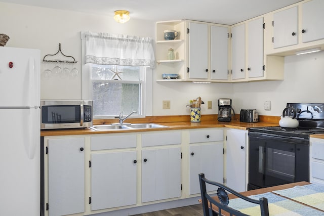 kitchen with sink, electric range, white fridge, dark hardwood / wood-style flooring, and white cabinetry