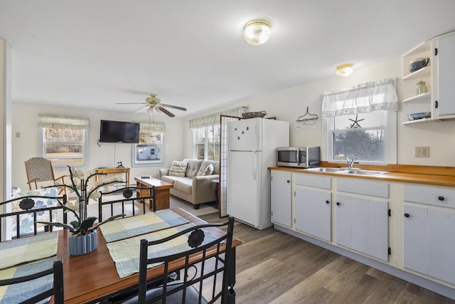 dining space featuring ceiling fan, sink, a wealth of natural light, and light hardwood / wood-style flooring