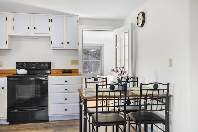 kitchen featuring black electric range, dark hardwood / wood-style floors, and white cabinetry