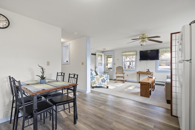 dining space with hardwood / wood-style floors, a baseboard radiator, french doors, and ceiling fan