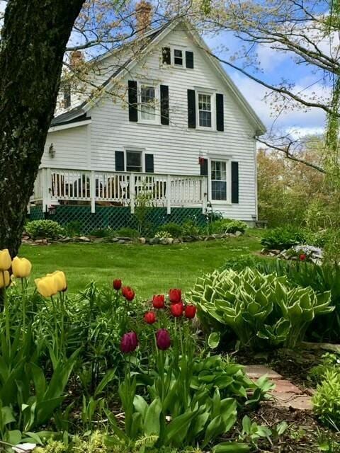 back of property featuring a yard and a deck