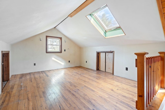 bonus room with vaulted ceiling with skylight and light hardwood / wood-style floors