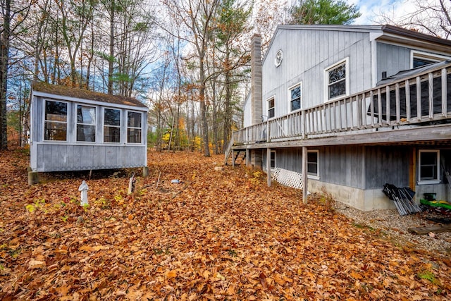 view of side of property featuring a sunroom and a wooden deck