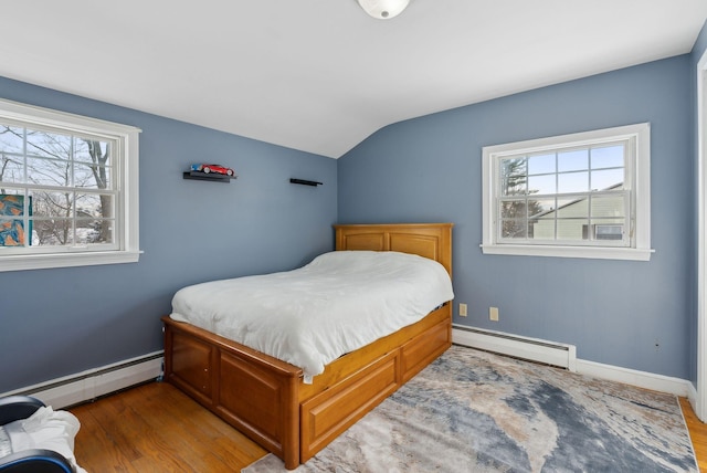 bedroom featuring hardwood / wood-style flooring, a baseboard heating unit, and lofted ceiling