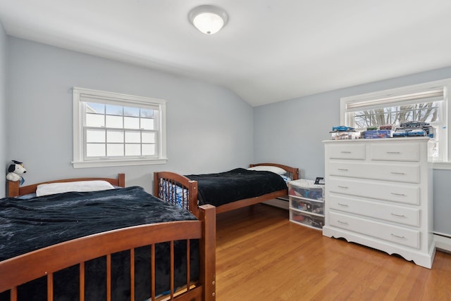 bedroom featuring lofted ceiling and light hardwood / wood-style floors