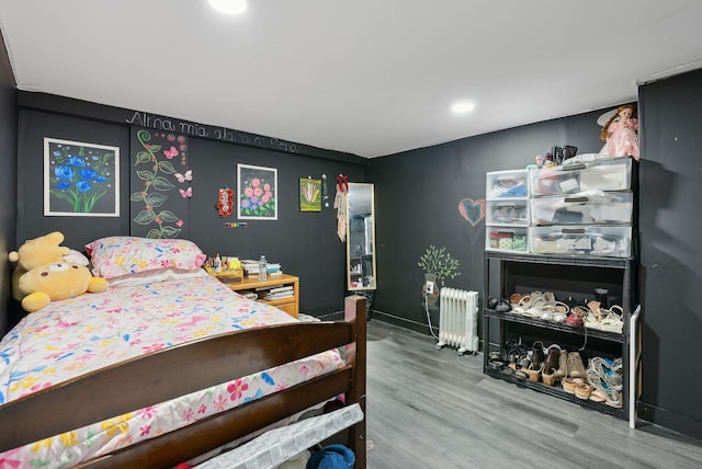 bedroom featuring hardwood / wood-style floors and radiator heating unit