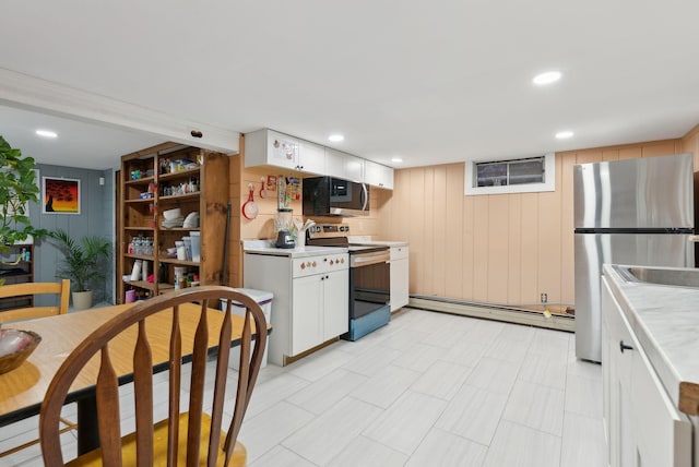 kitchen featuring appliances with stainless steel finishes, white cabinets, and a baseboard heating unit