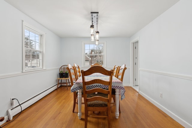 dining area with light wood-type flooring and a baseboard radiator