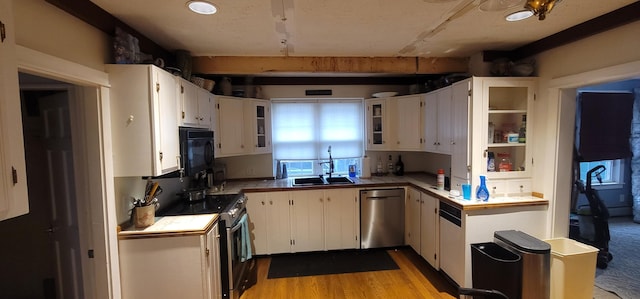 28 Maine Ave, Millinocket, ME 04462 - kitchen with stainless steel appliances, white cabinets, glass insert cabinets, light wood finished floors, and plenty of natural light