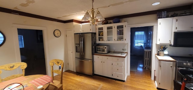 28 Maine Ave, Millinocket, ME 04462 - kitchen with appliances with stainless steel finishes, light wood-style flooring, white cabinets, glass insert cabinets, and a chandelier