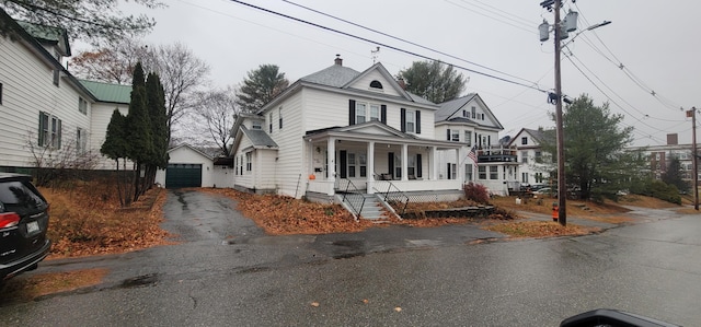 28 Maine Ave, Millinocket, ME 04462 - american foursquare style home with covered porch, an outbuilding, a garage, driveway, and a chimney