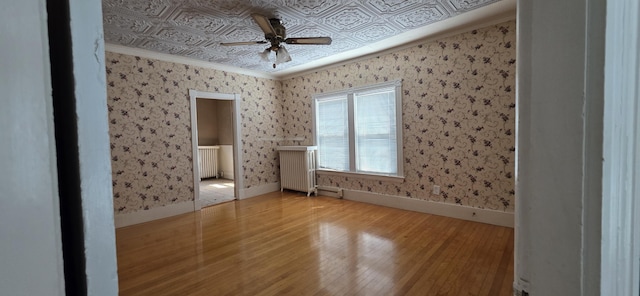 28 Maine Ave, Millinocket, ME 04462 - unfurnished bedroom featuring wood-type flooring, ornamental molding, an ornate ceiling, radiator, and ceiling fan