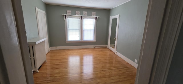 28 Maine Ave, Millinocket, ME 04462 - spare room featuring light wood-style flooring, radiator heating unit, and crown molding