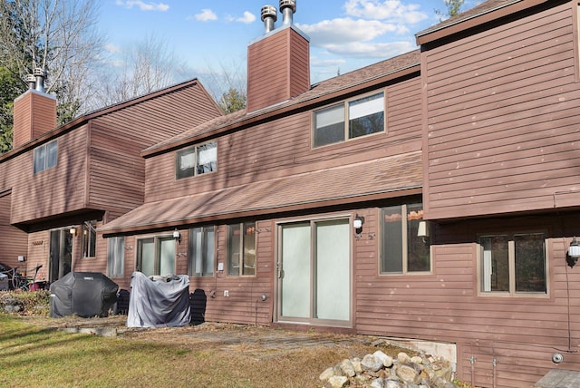 rear view of house featuring a lawn