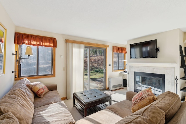 living room featuring a tile fireplace, light carpet, and plenty of natural light