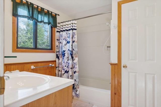 bathroom featuring sink, shower / bath combo with shower curtain, and wood walls