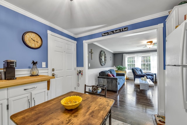 dining space featuring ornamental molding, ceiling fan, and dark wood-type flooring