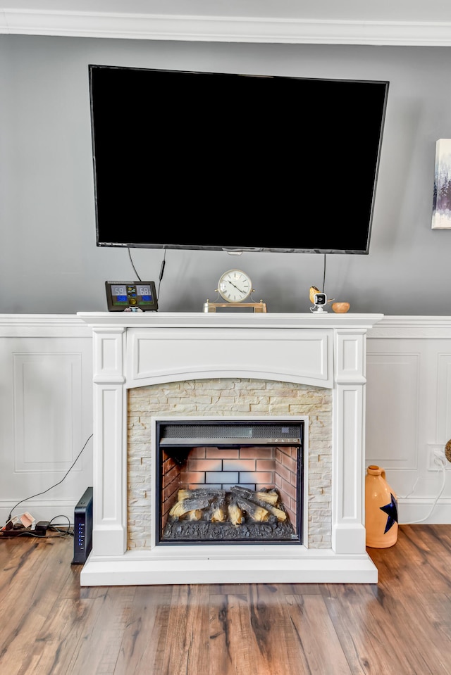 details featuring hardwood / wood-style flooring, ornamental molding, and a fireplace