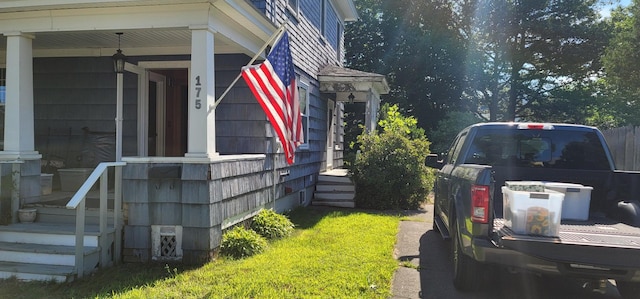 view of side of home featuring covered porch